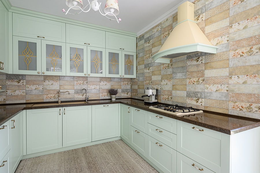 Modern kitchen with light green cabinetry and maximized space.